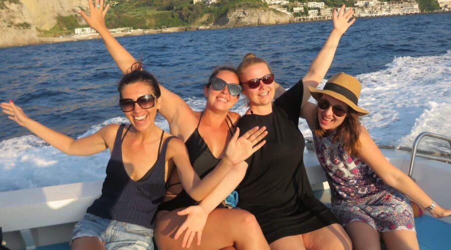 Four happy and excited women on a boat