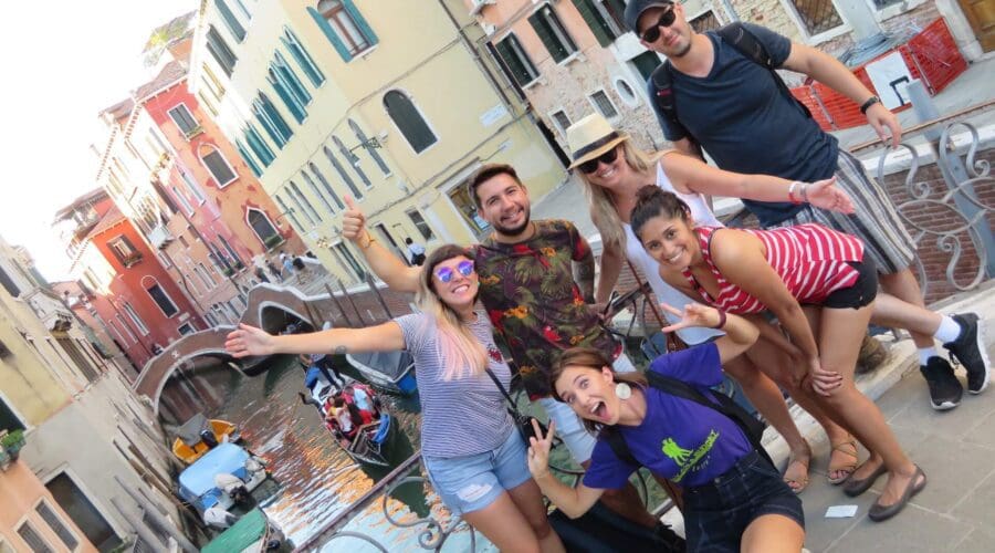 A fun group picture on a small bridge in Venice with the colorful houses and canal in the background