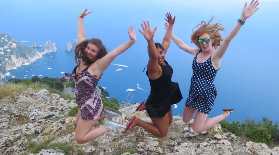 Three friends jumping in front of a viewpoint in Anacapri