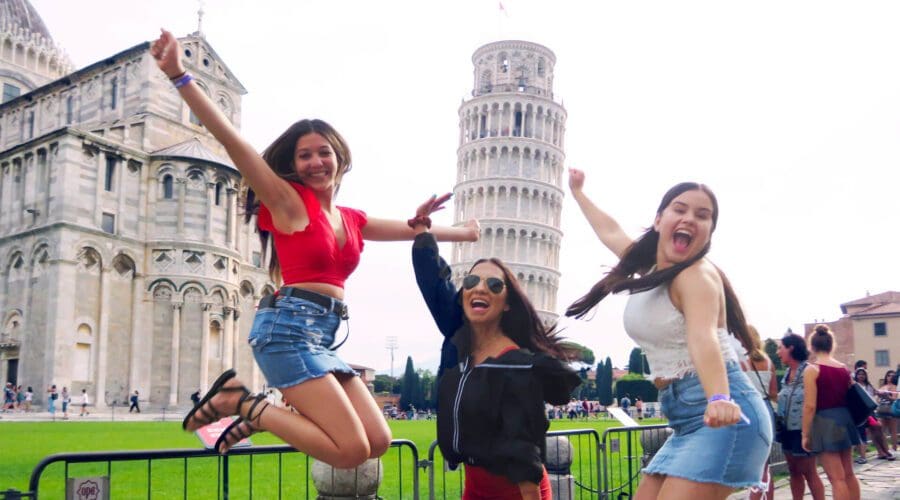 Three friends jumping in front of Leaning Tower of Pisa