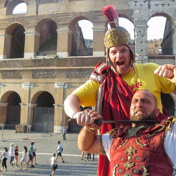 People fake fighting and dressed as gladiators in front of the colosseum