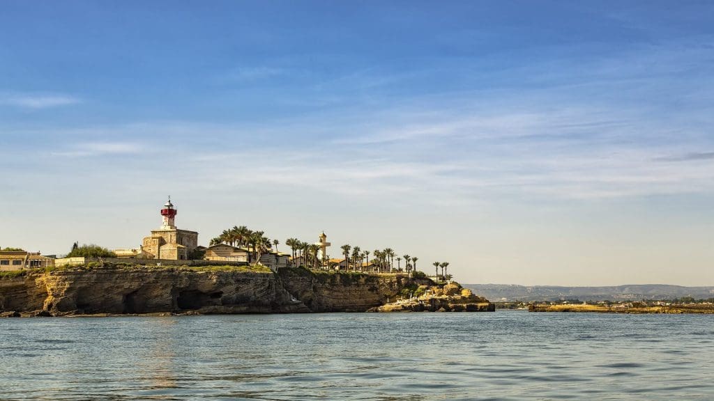 cenic view of a lighthouse perched on a rocky island surrounded by the vast water.