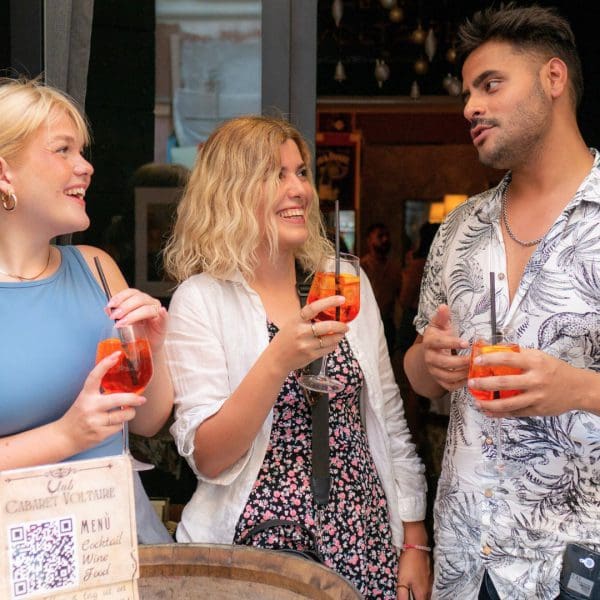friends drinking aperol spritz while talking and laughing